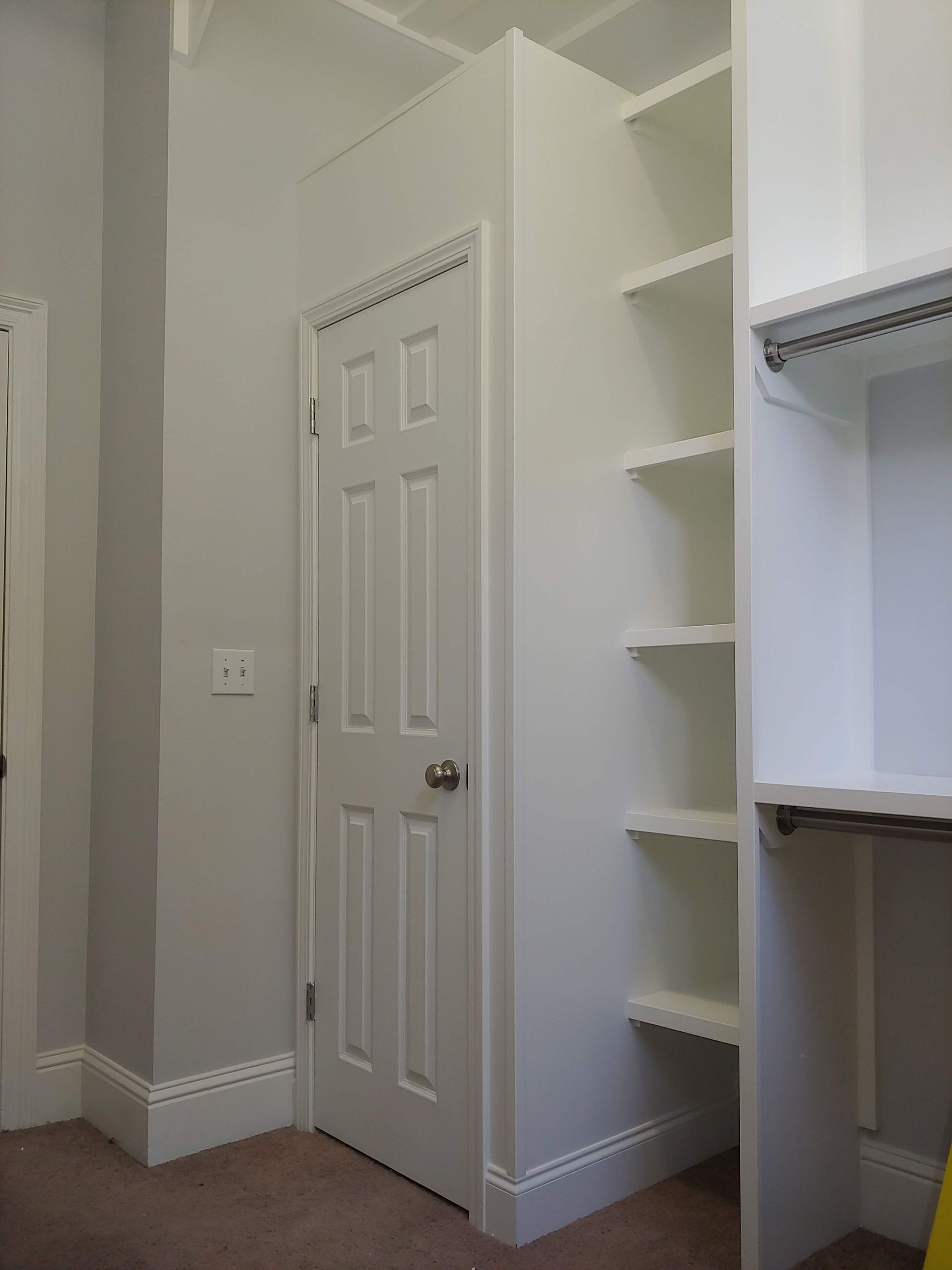 A room with a door and shelves in it