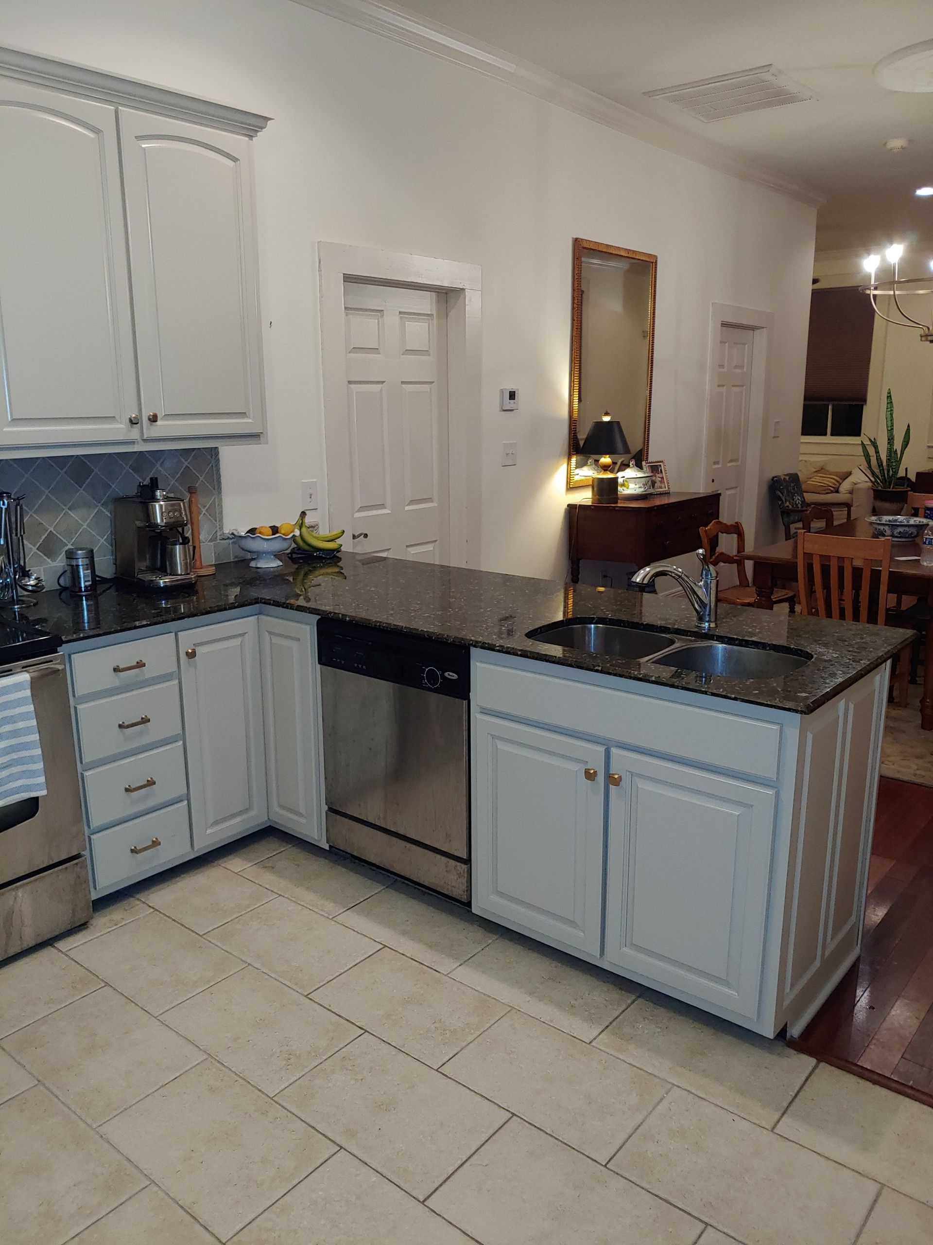 A kitchen with white cabinets and granite counter tops