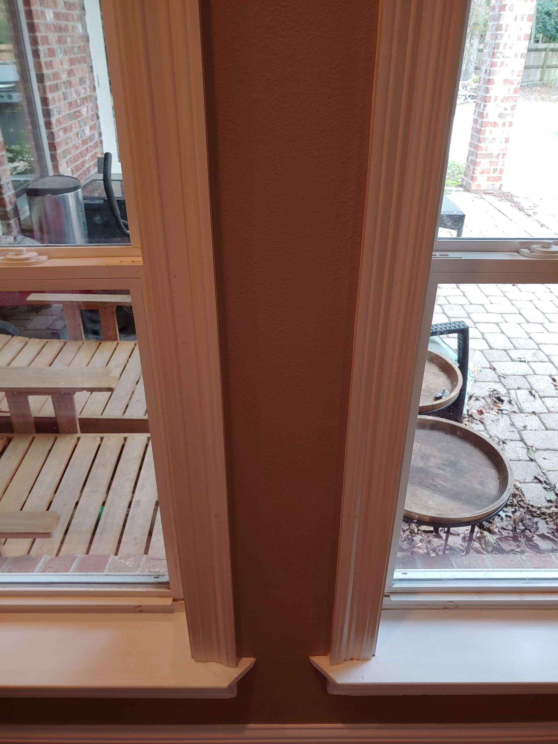 A close up of a window with a brick wall in the background.