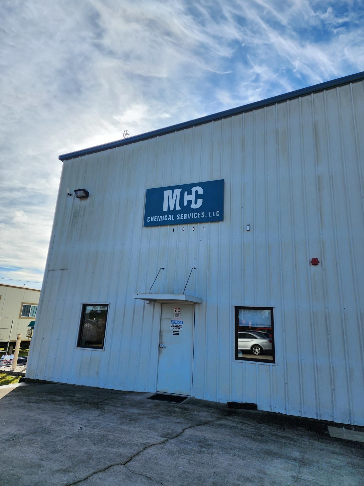 A white building with a blue sign that says mc on it.
