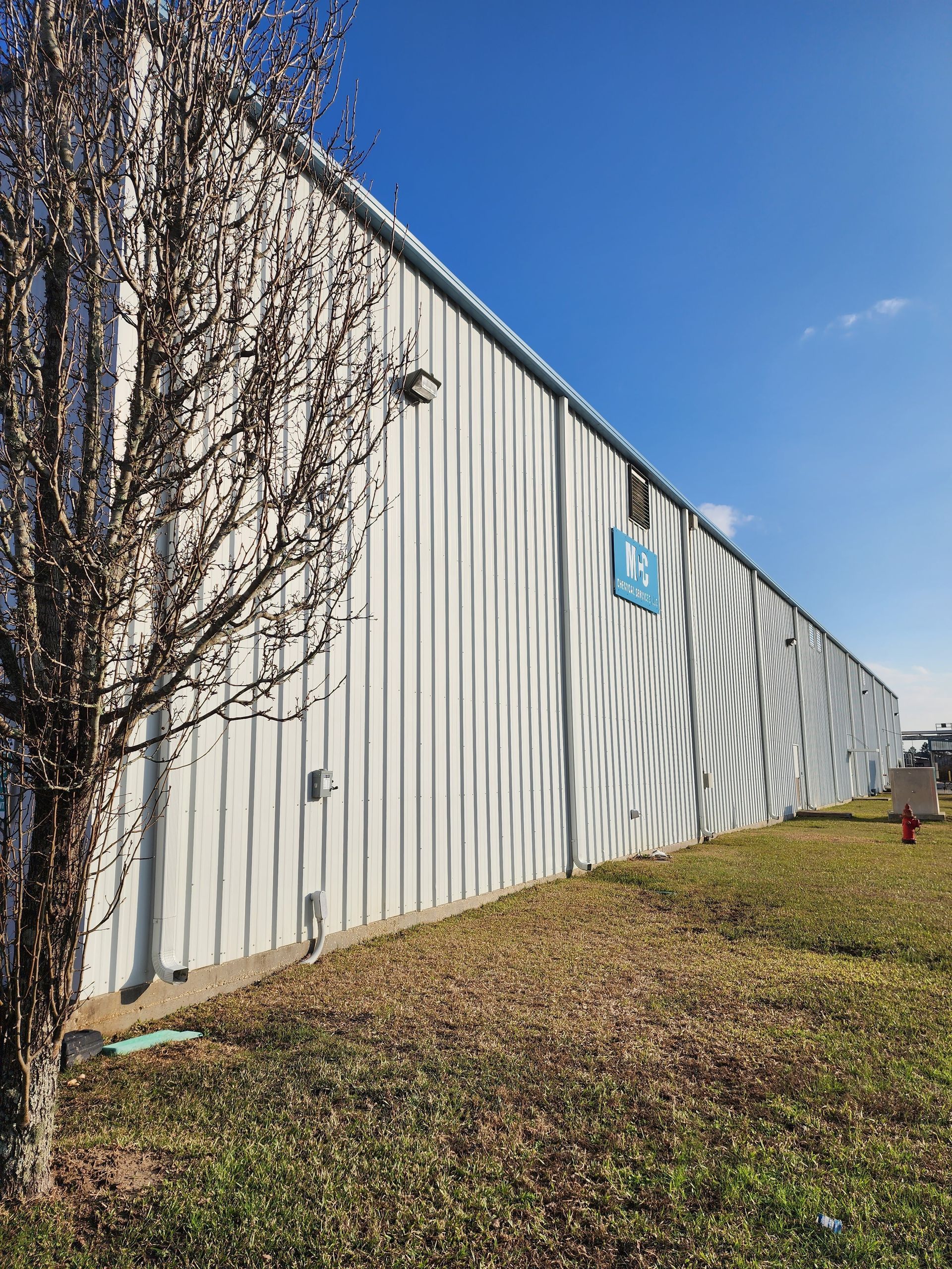 A large white building with a tree in front of it.