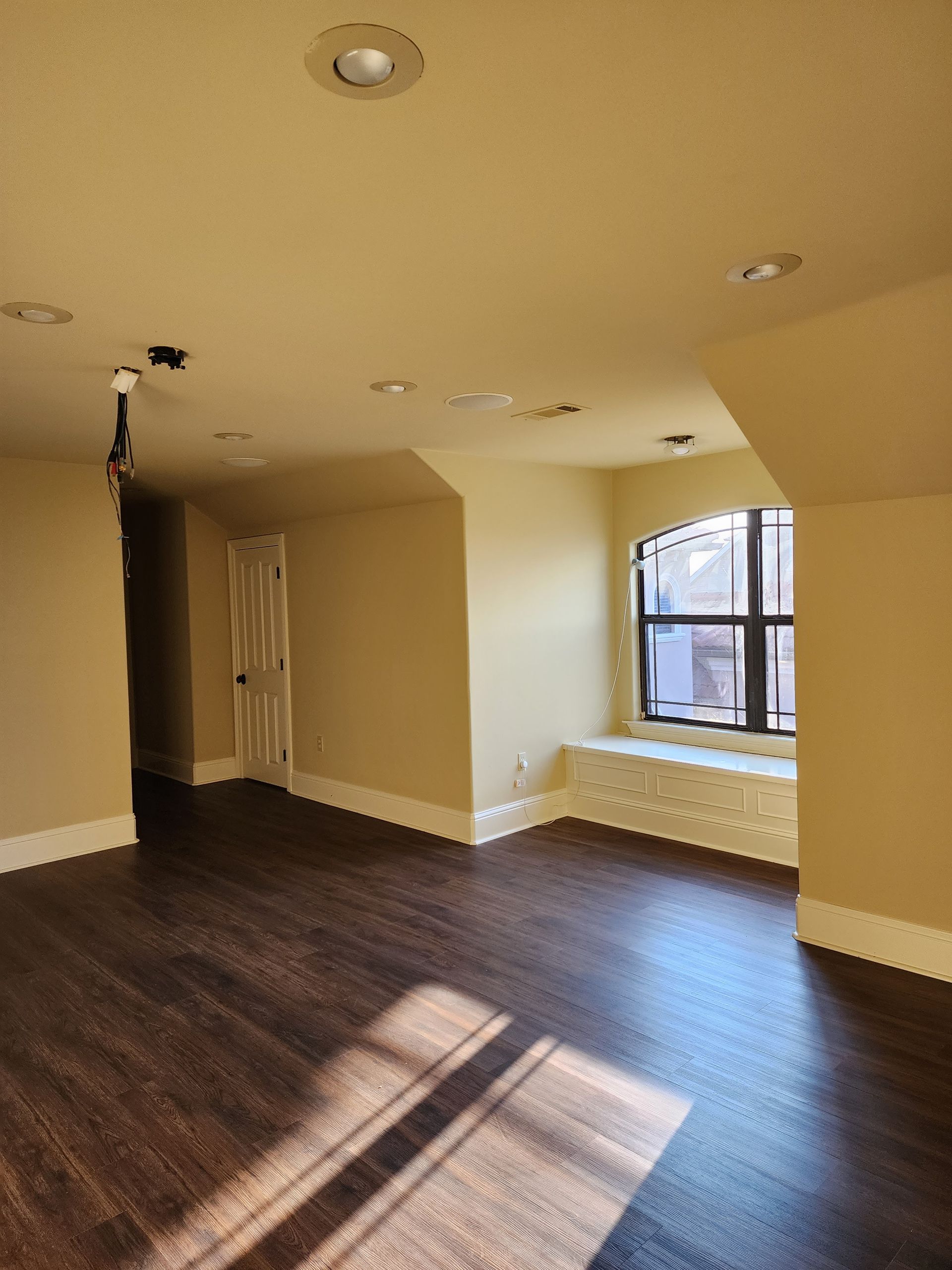 An empty room with hardwood floors and a window