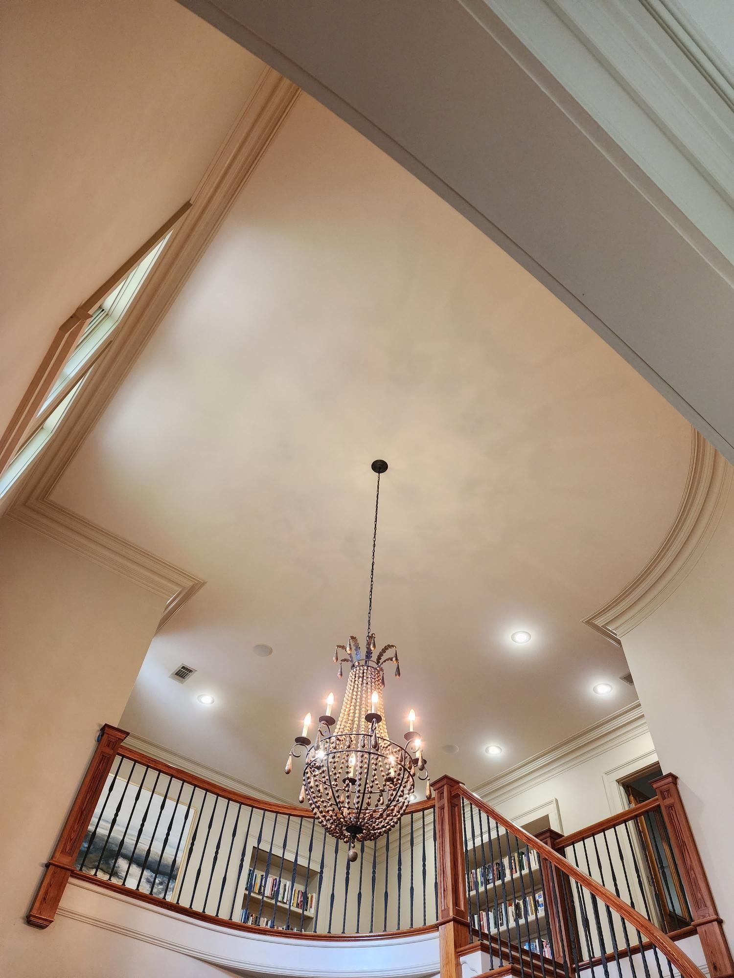 Looking up at a chandelier hanging from the ceiling of a house