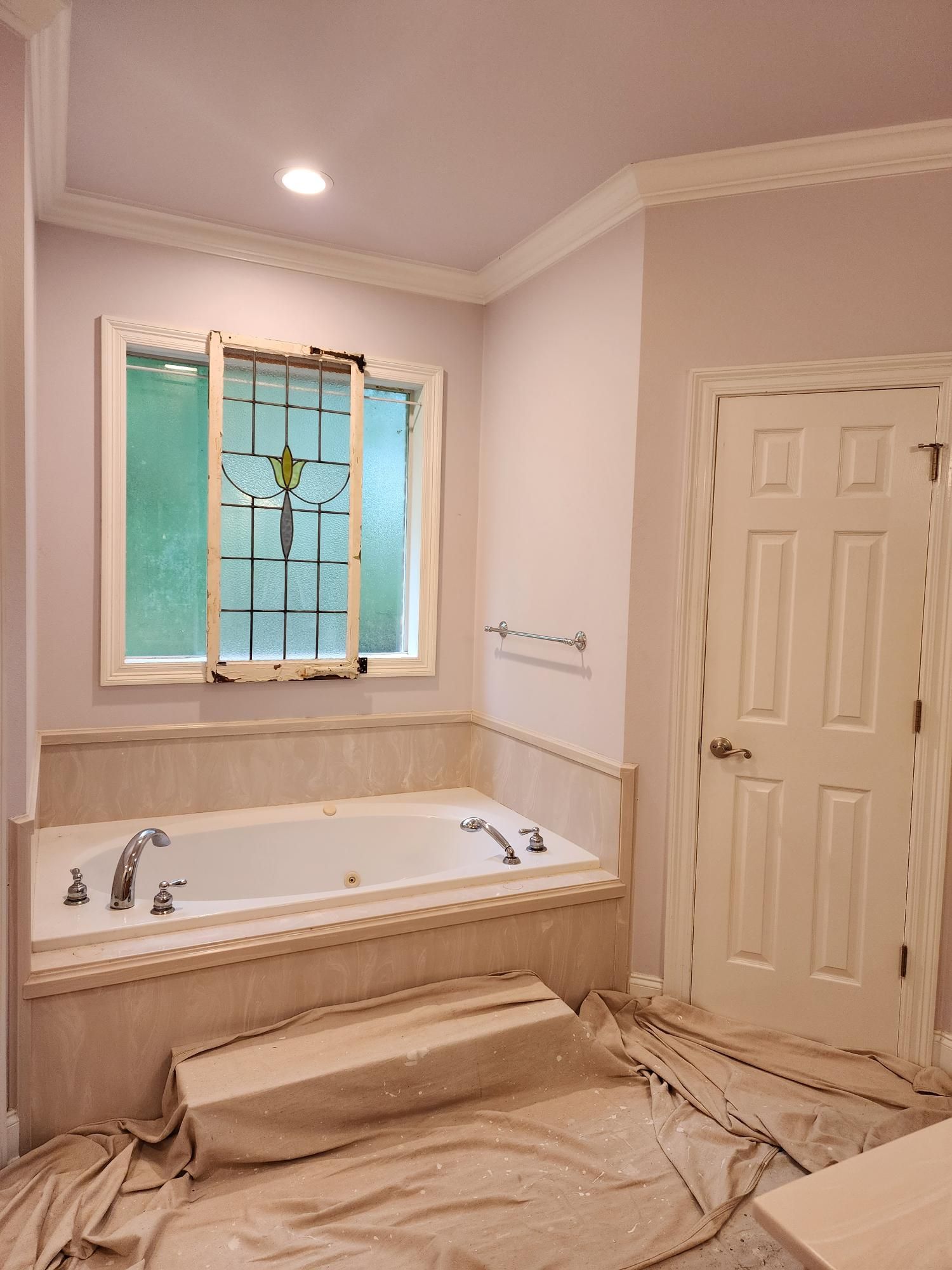A bathroom with a jacuzzi tub and a window.