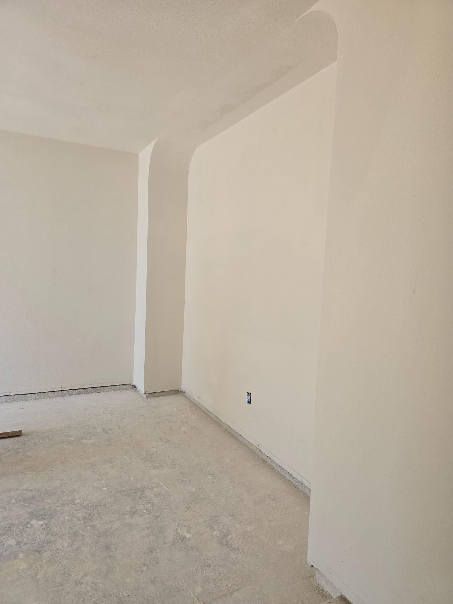An empty room with white walls and a concrete floor.