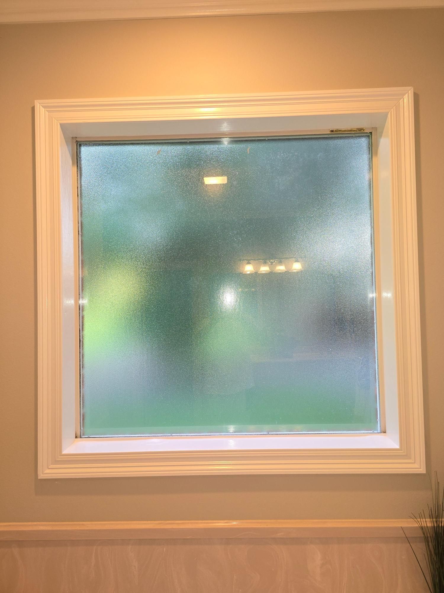 A bathroom window with a frosted glass window.