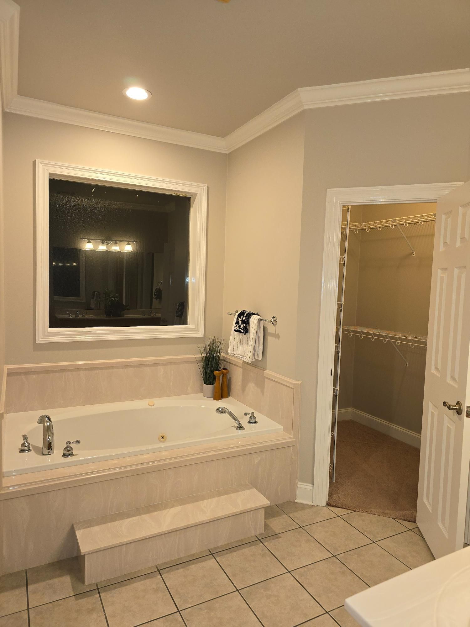 A bathroom with a jacuzzi tub and a window.