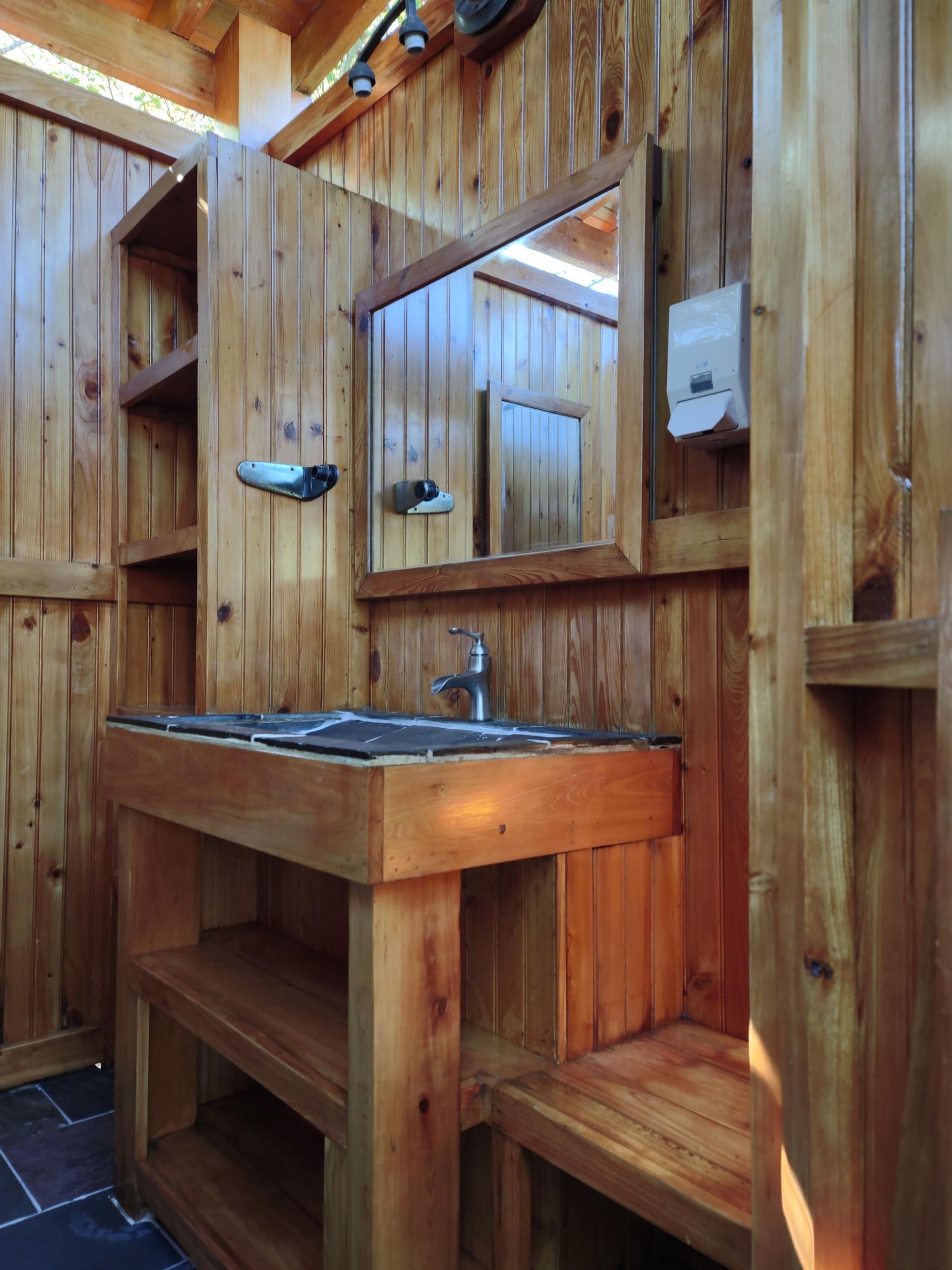 A wooden bathroom with a sink and a mirror