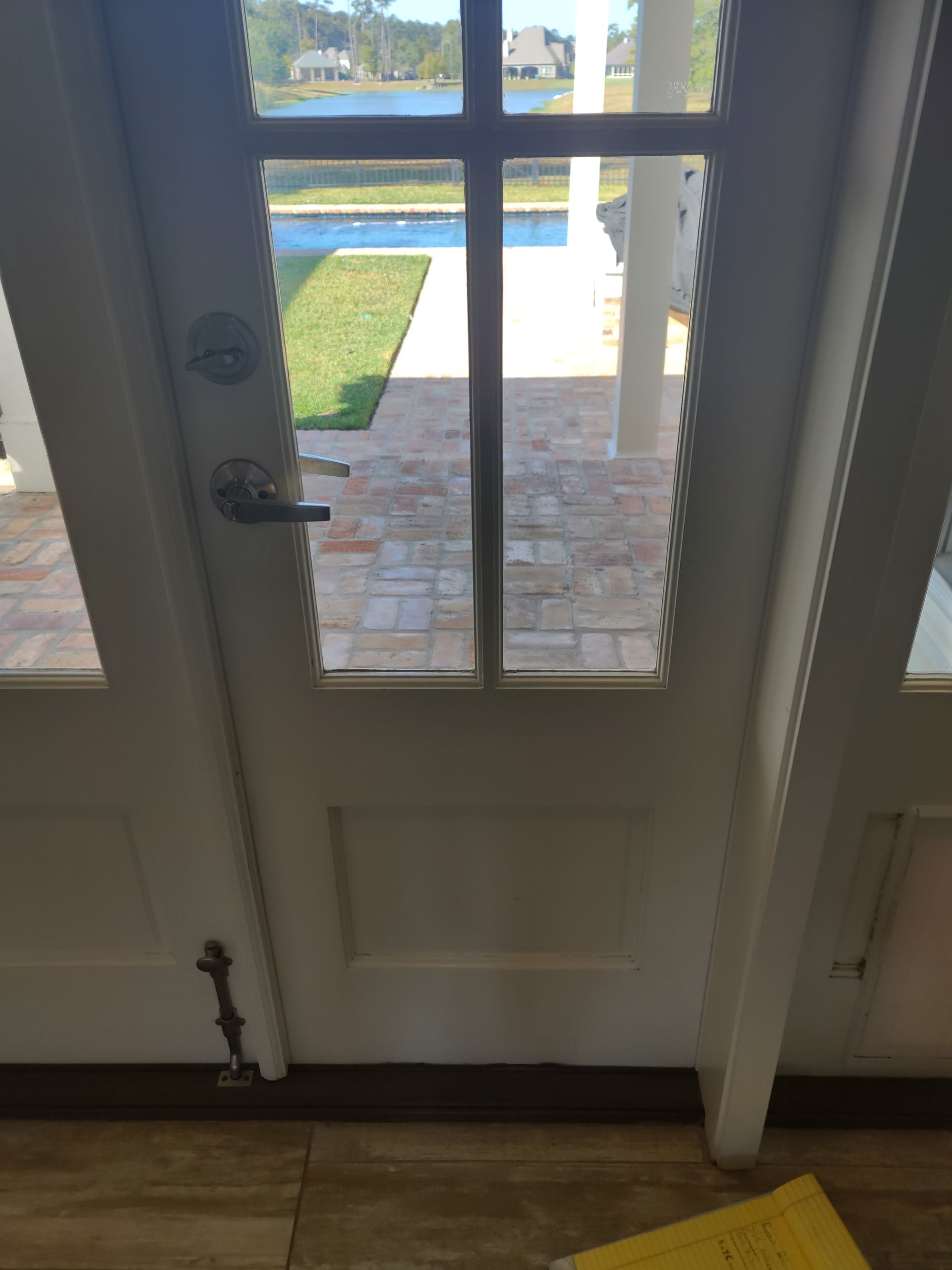 A door with a view of a patio and a pool.