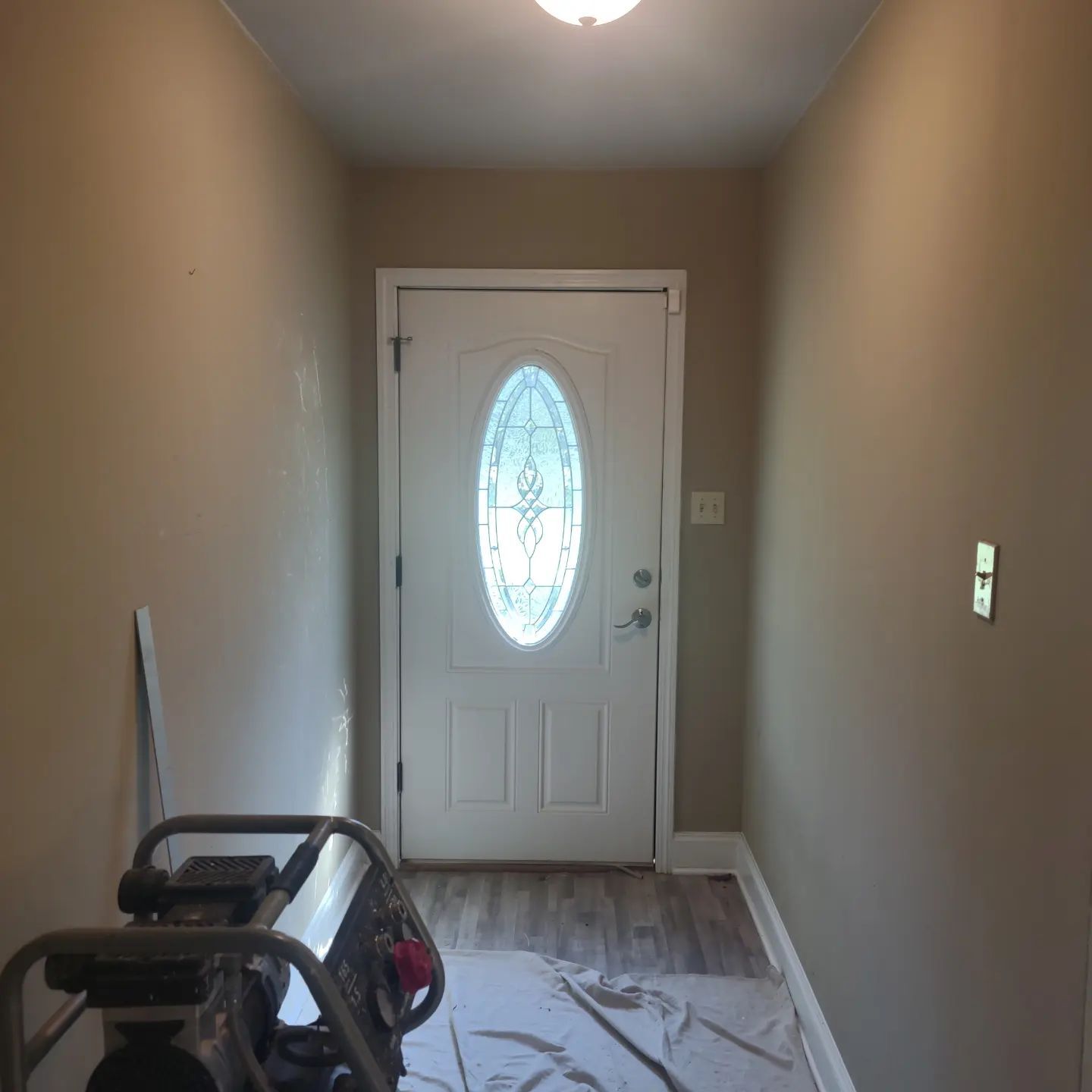 A hallway with a white door and a stained glass window.