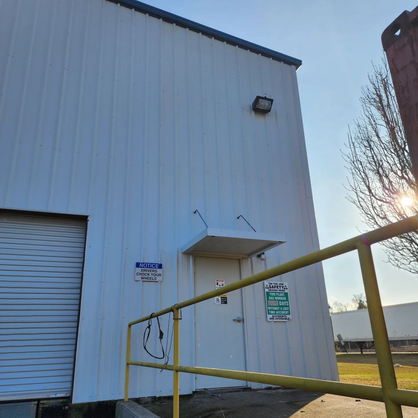 A white building with a yellow railing leading to the door