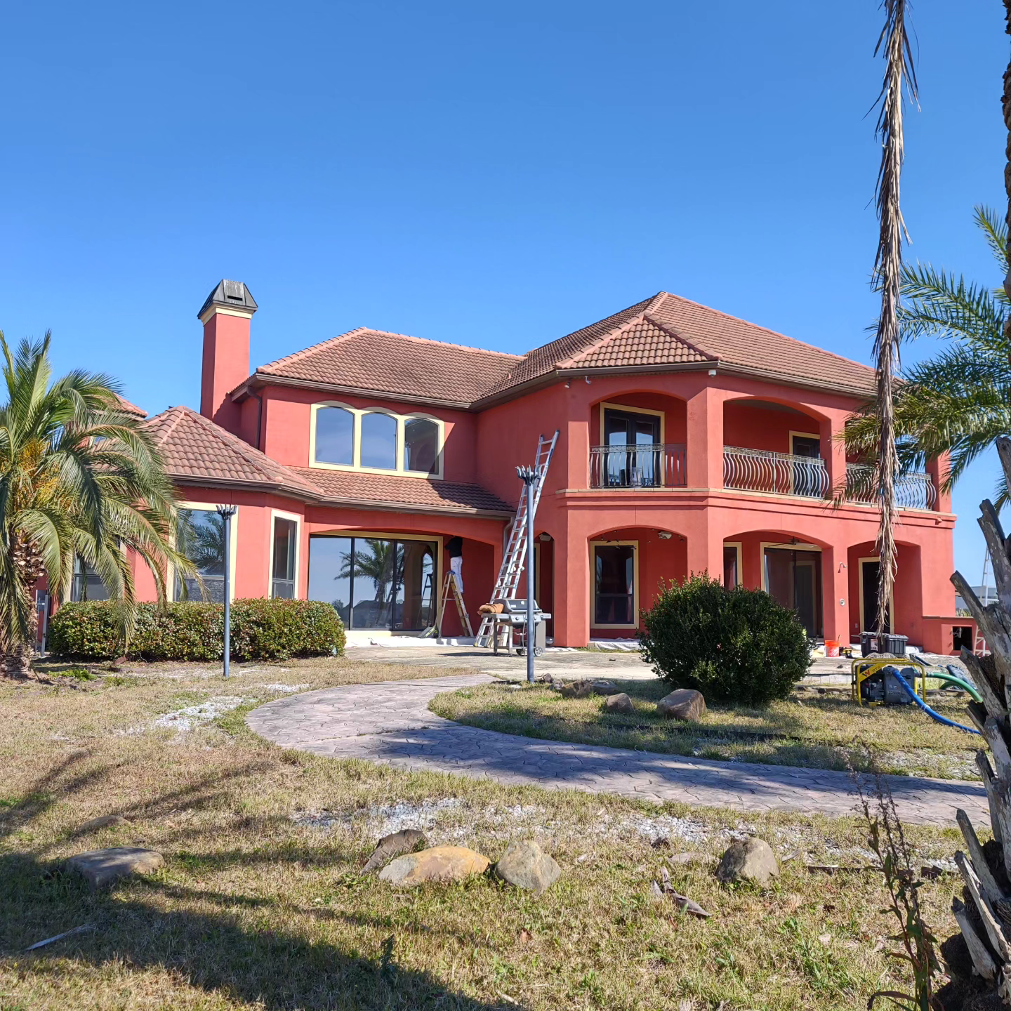 A large red house with a ladder in front of it