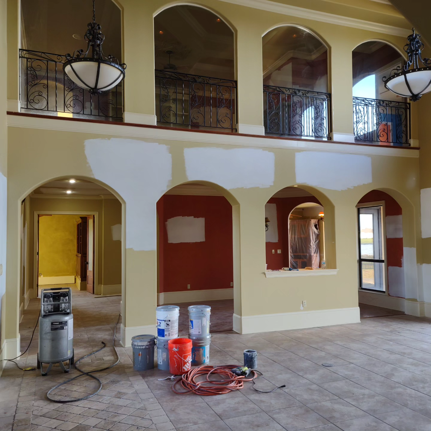 An empty room with buckets of paint on the floor