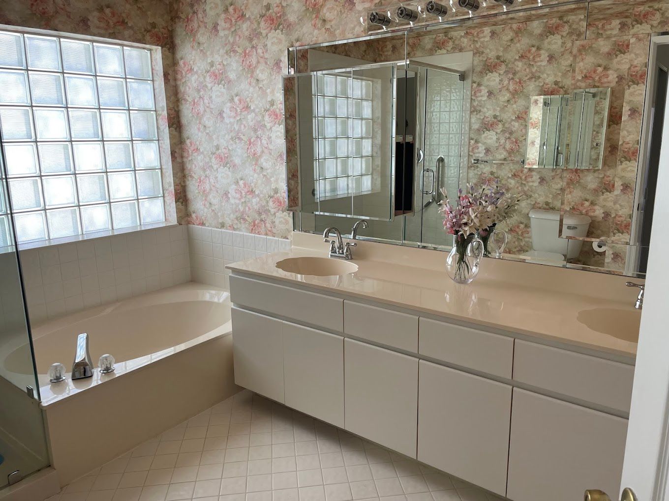 A bathroom with two sinks , a tub and a mirror.