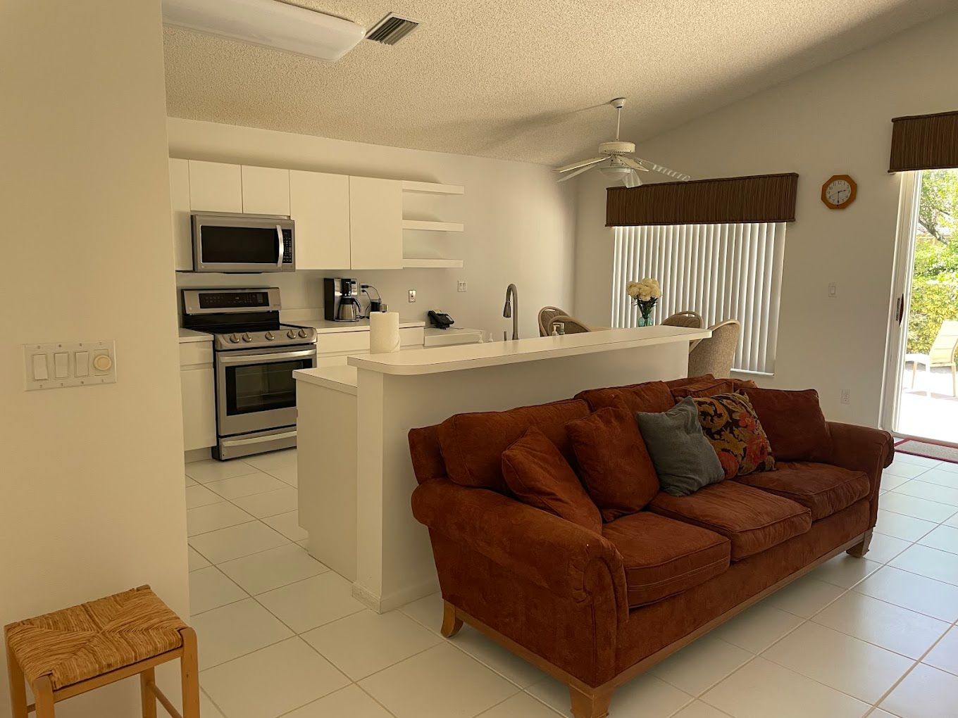 A living room with a couch and a kitchen in the background