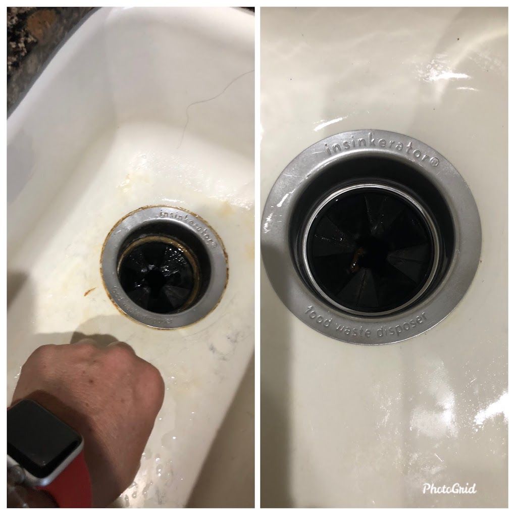 A person is cleaning a sink drain with a sponge.