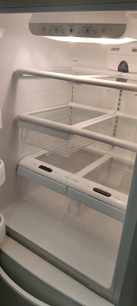 The inside of an empty refrigerator with empty shelves.