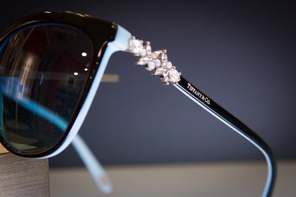 Occhiali da sole Tiffany & Co., montatura nera e blu con decorazioni gioiello, primo piano.