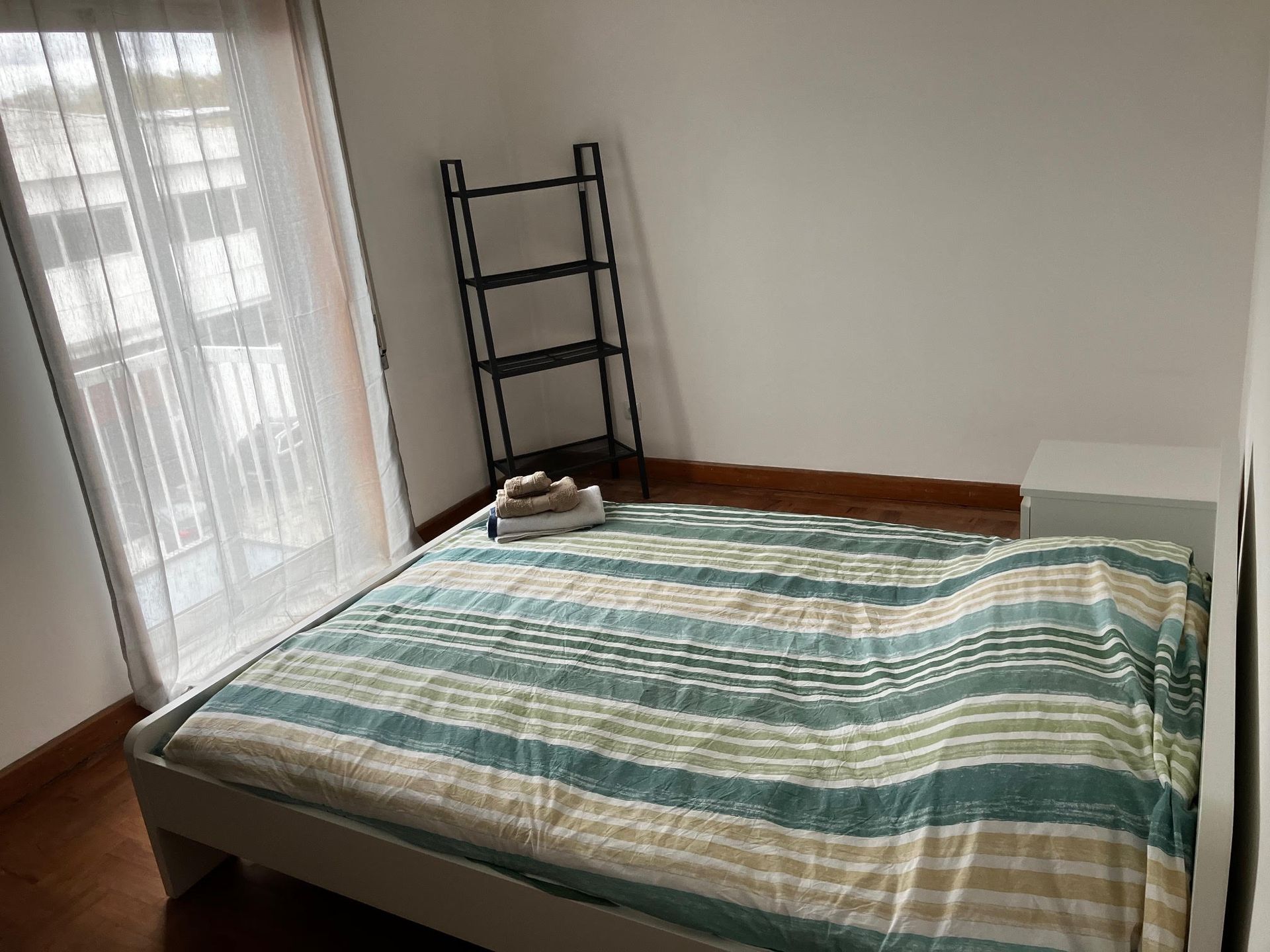 A bedroom with a bed and a ladder in the corner