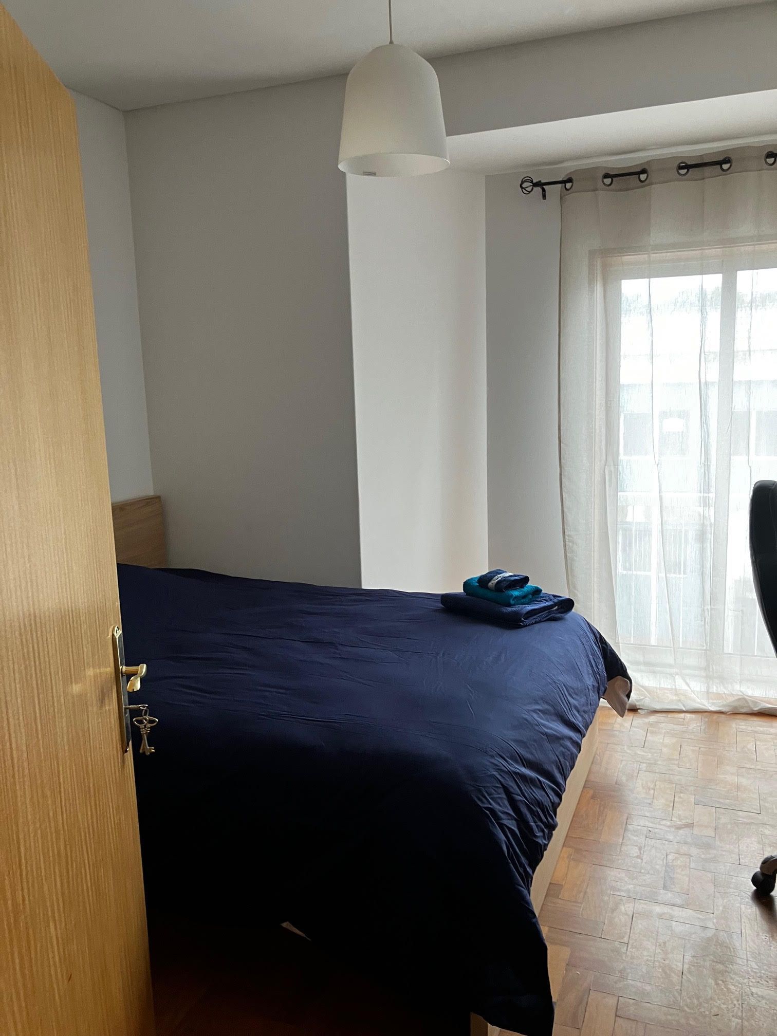 A bedroom with a bed and a sliding glass door