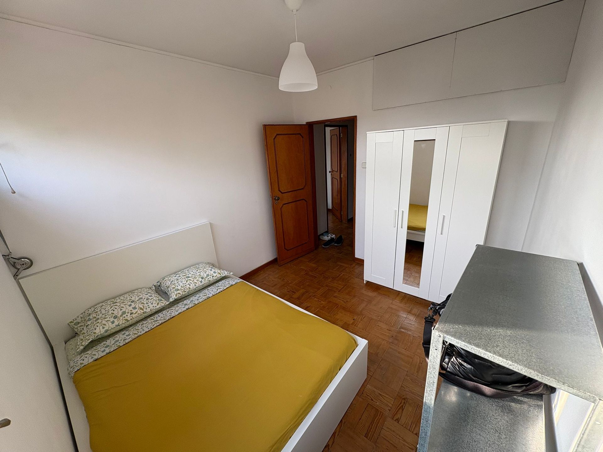 A bedroom with a bed a desk and a chair