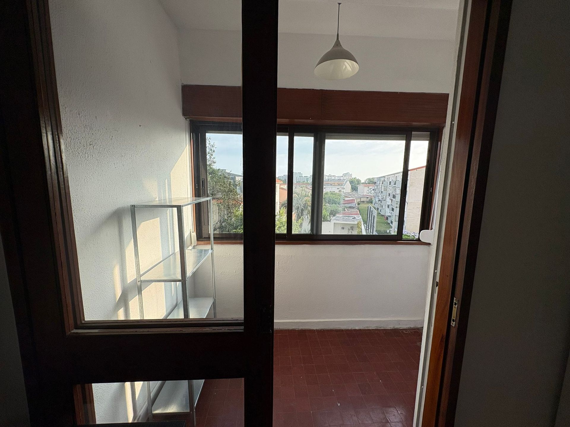 A bedroom with a desk and chair in front of a window