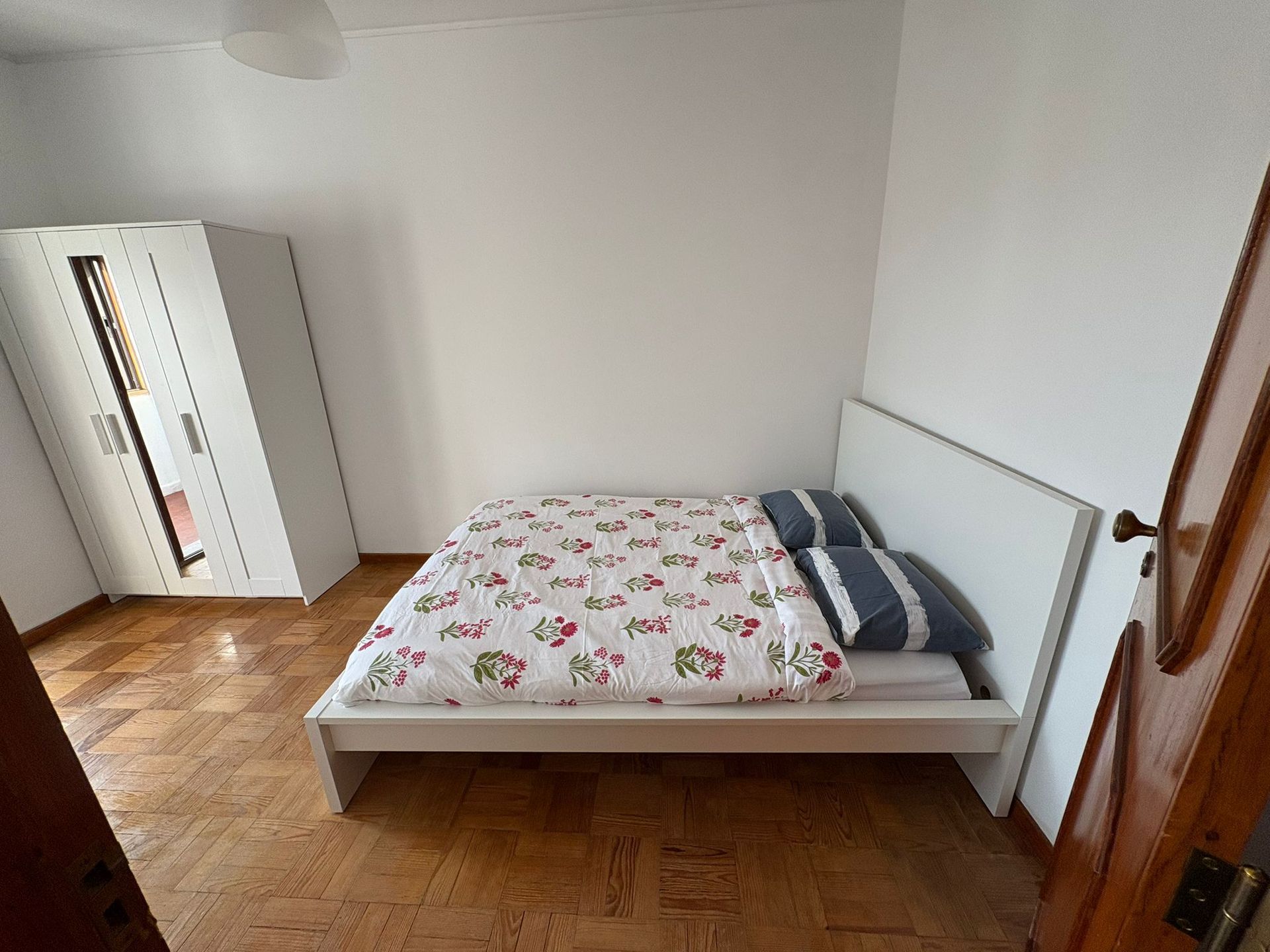 A bedroom with a bed and a ladder in the corner