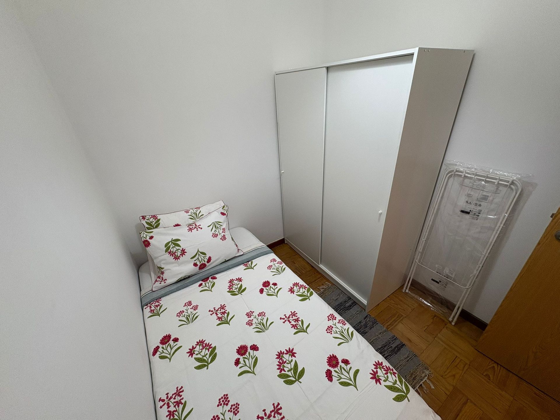 A bedroom with a desk chair and a nightstand