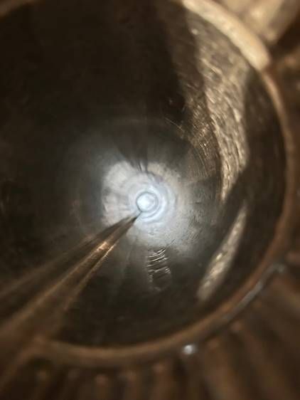 A close up of a metal object with a light coming out of it.