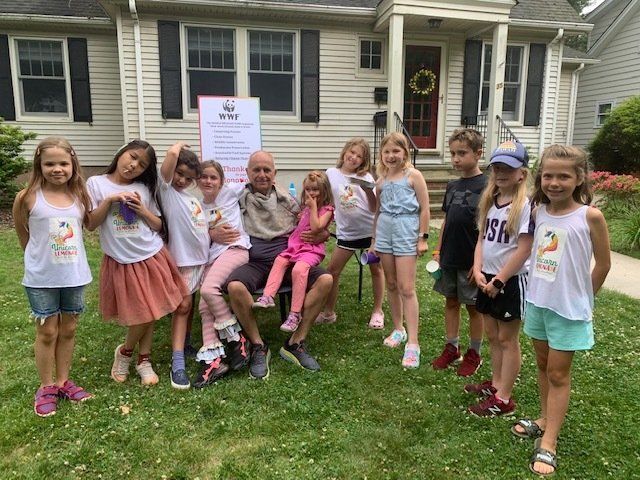 A group of children are posing for a picture in front of a house.