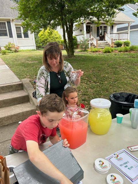 A woman and two children are sitting at a table with drinks