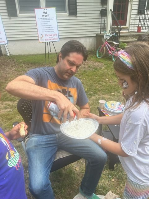 A man and a little girl are playing with a plate of food.