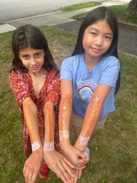 two girls with paint on their arms