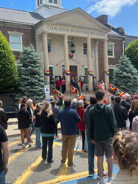 A group of people standing in front of a building that says can rock municipal building