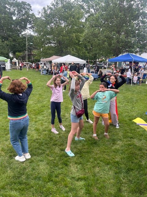 A group of young girls are dancing in a park.