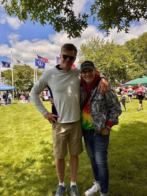 A man and a woman are posing for a picture in a park.