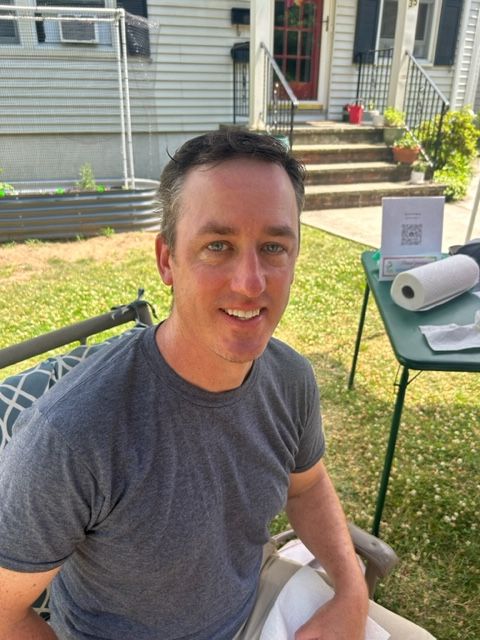 A man is sitting in front of a table with paper towels on it.