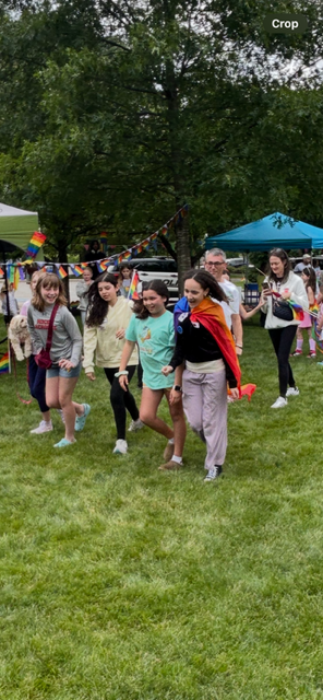 A group of people are running in a grassy field.