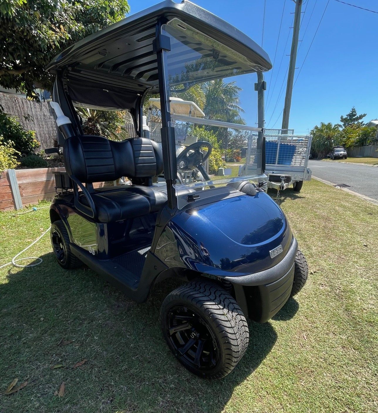 A Blue Golf Cart is Sitting on Top of a Lush Green Grass — Buggies & Batteries in Hidden Valley, QLD