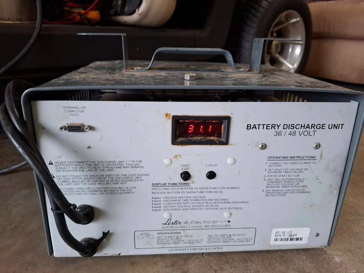 A Battery Charger is Sitting on the Floor Next to a Golf Cart — Buggies & Batteries in Rockhampton, QLD