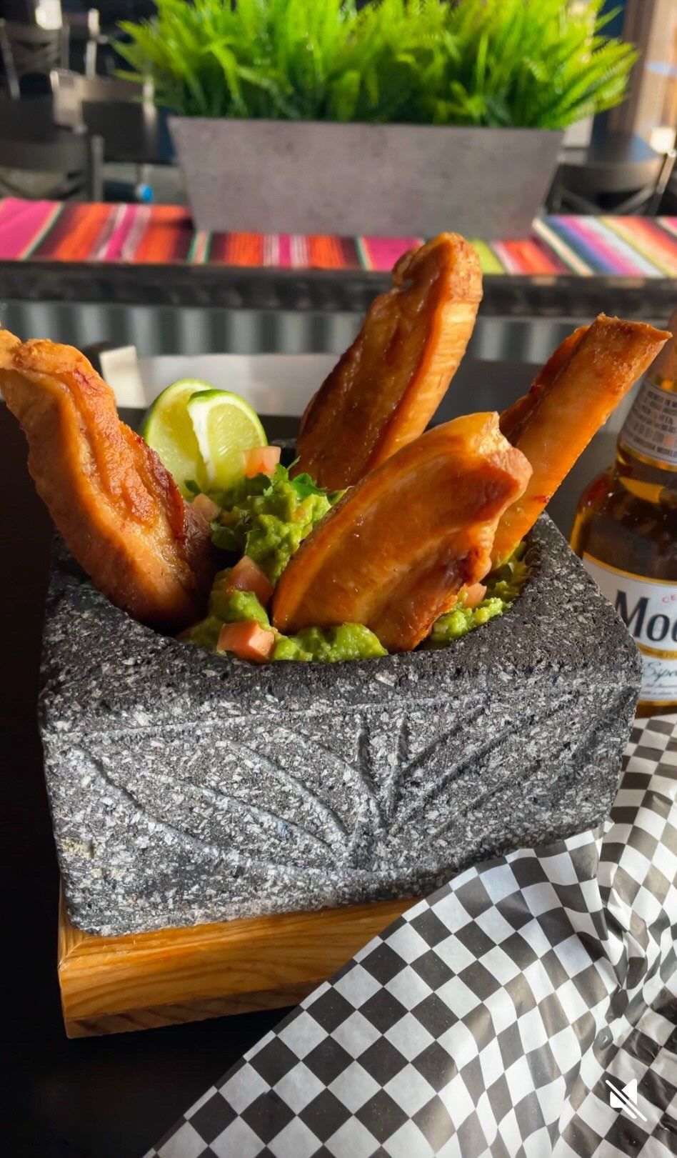 A close up of a plate of food with guacamole on a table.