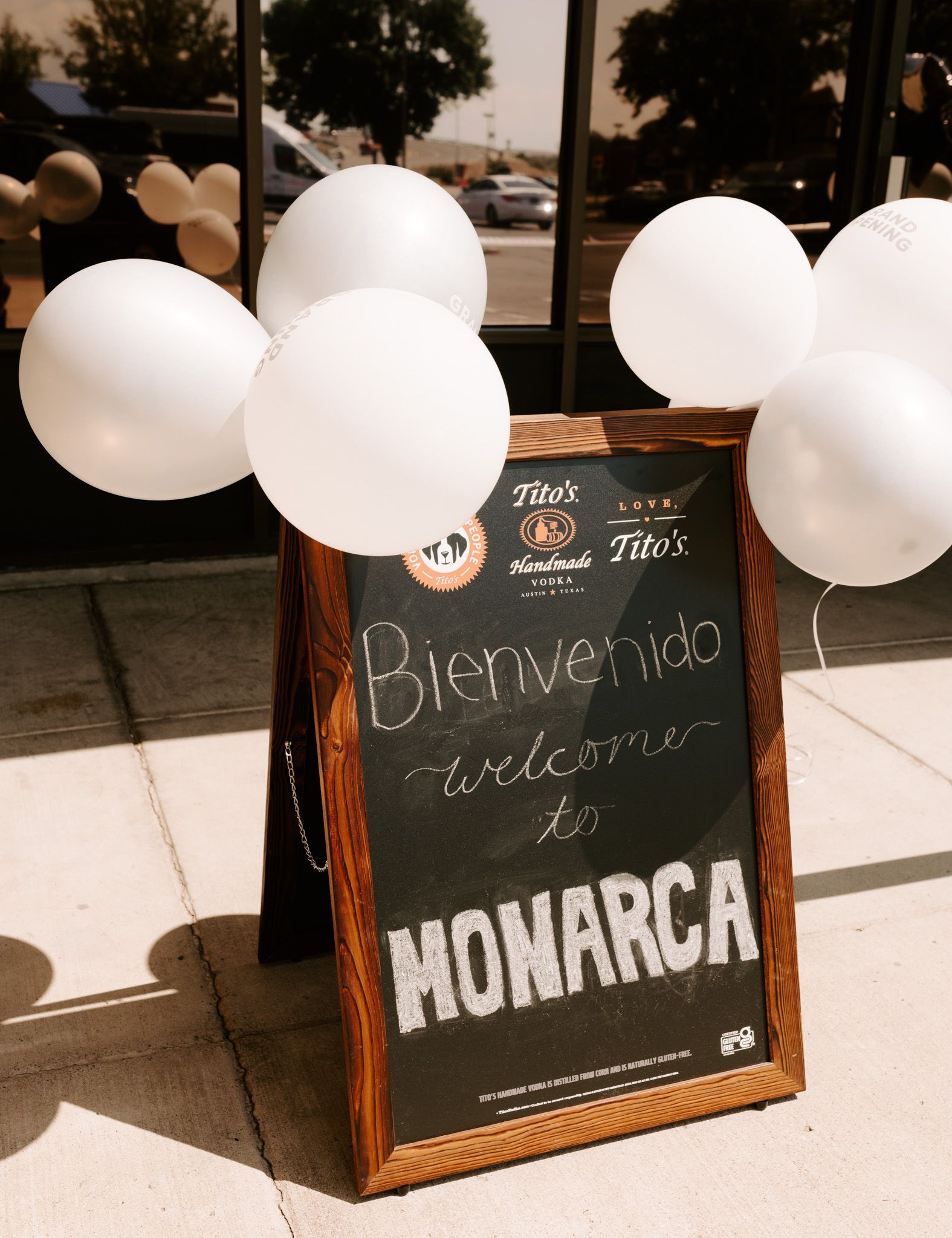 A sign that says monarca is surrounded by white balloons