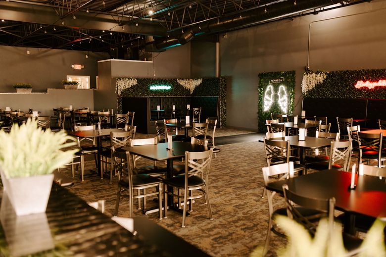 A restaurant with tables and chairs in a large room.