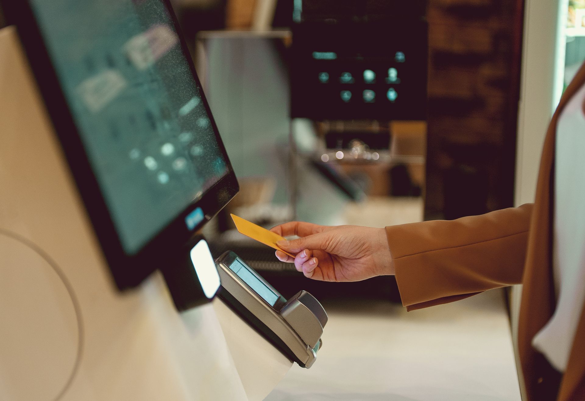 Person scans smartphone with a barcode reader at a counter.