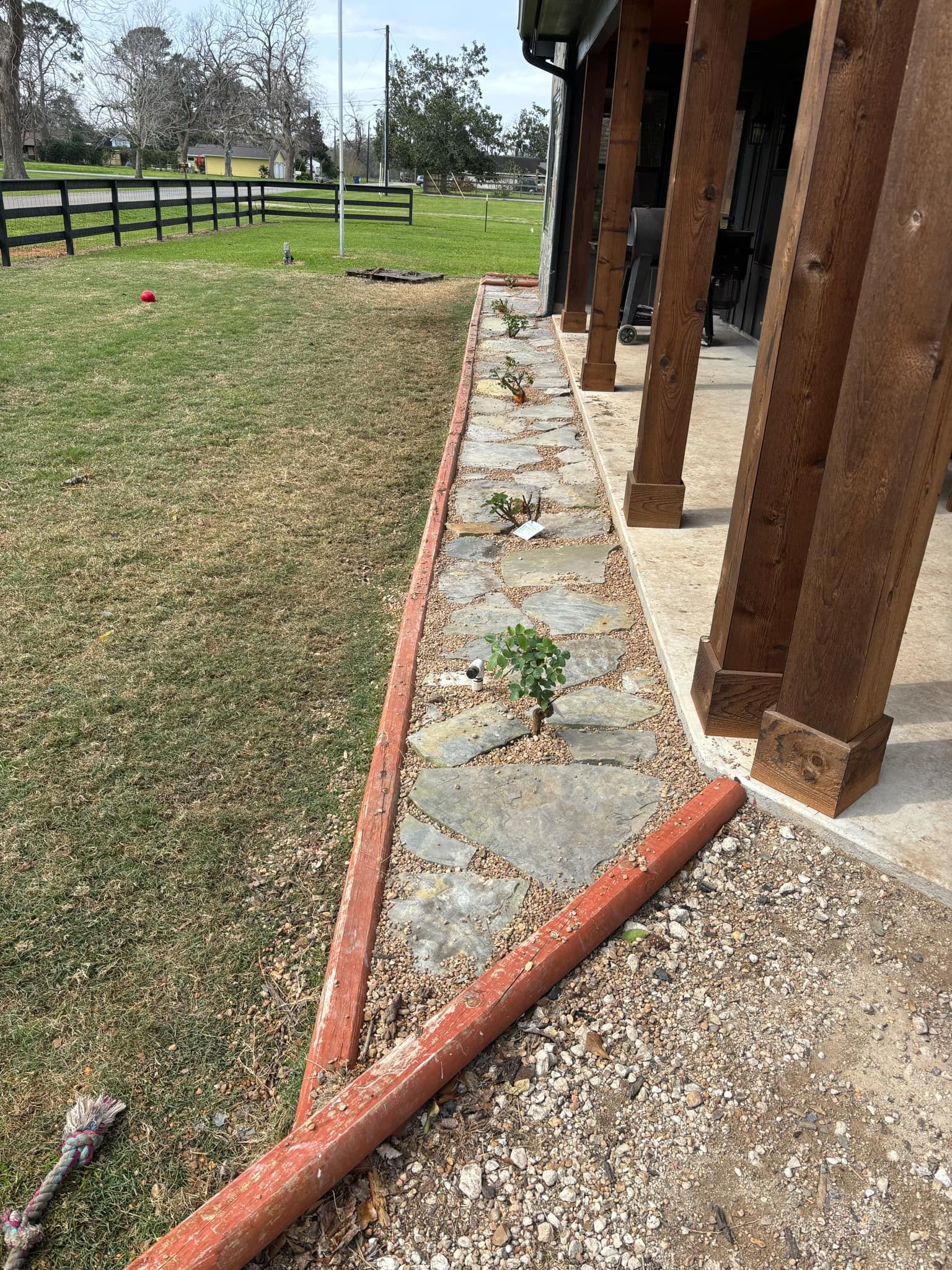 A red border frames the bed, and gravel lines the walkway.