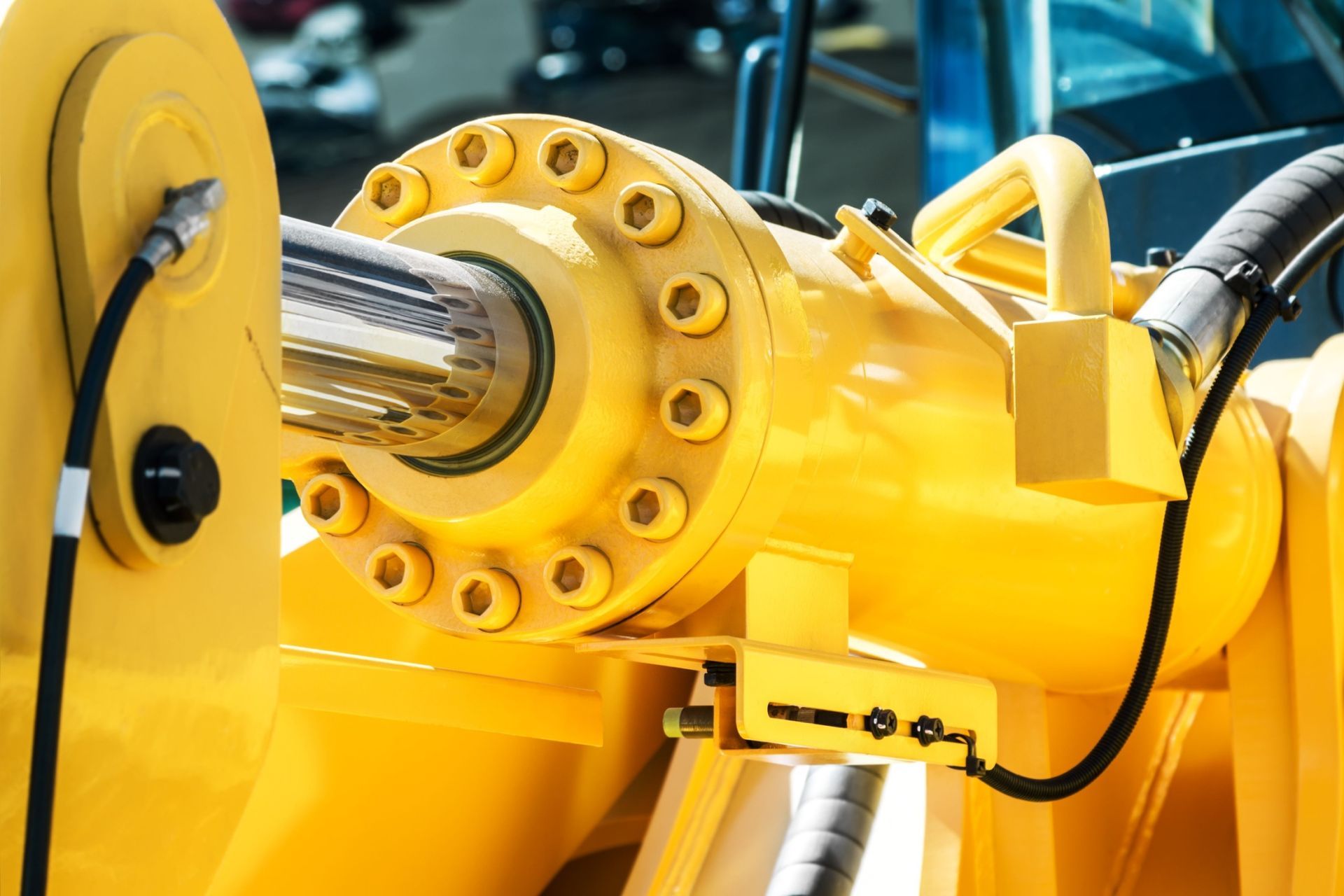 A close up of a yellow hydraulic cylinder on a machine.