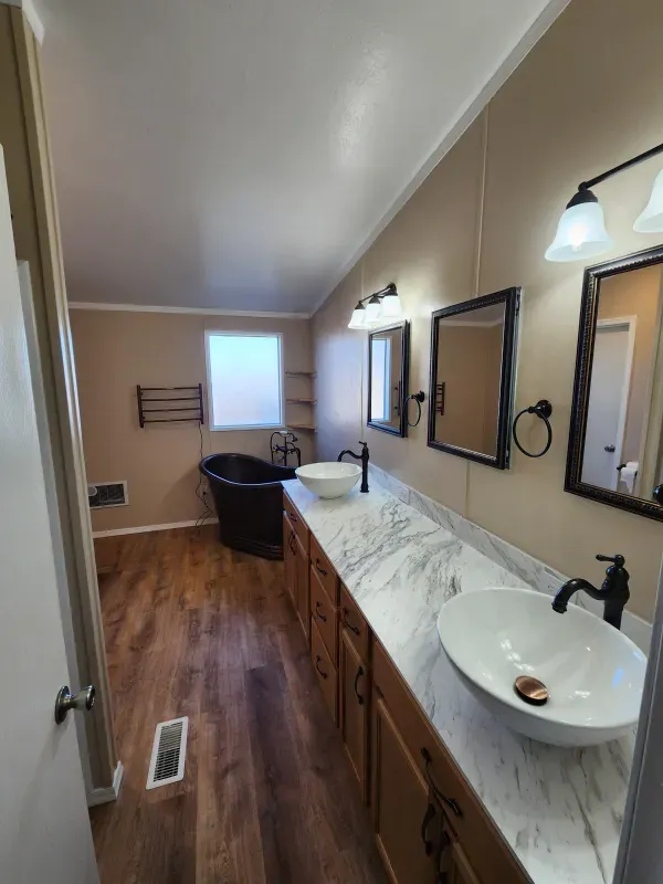 A bathroom with two sinks and a tub.