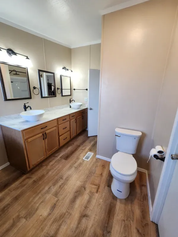 A bathroom with two sinks and a toilet.