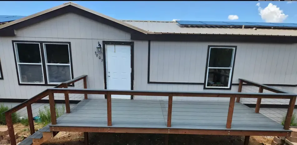A mobile home with a large deck in front of it