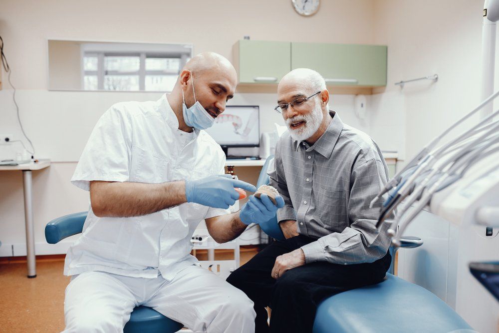 dentist showing patient their new dentures
